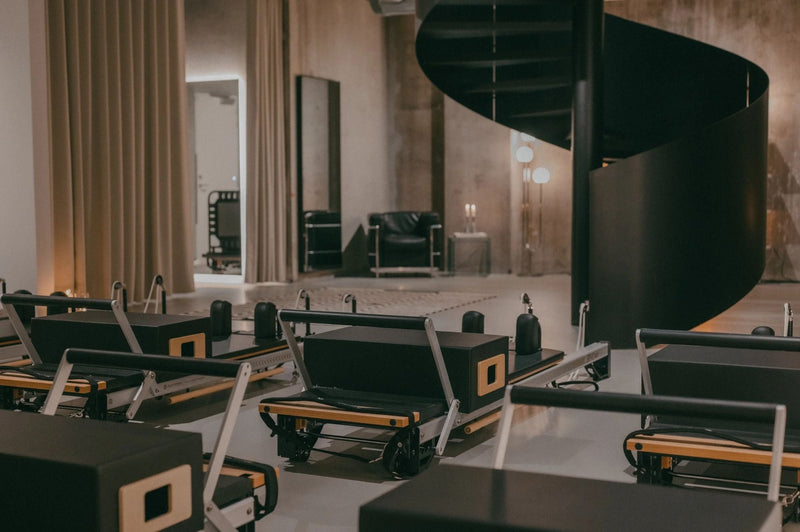 Reformer machines and spiral staircase in the Sink Reformer studio in Aarhus