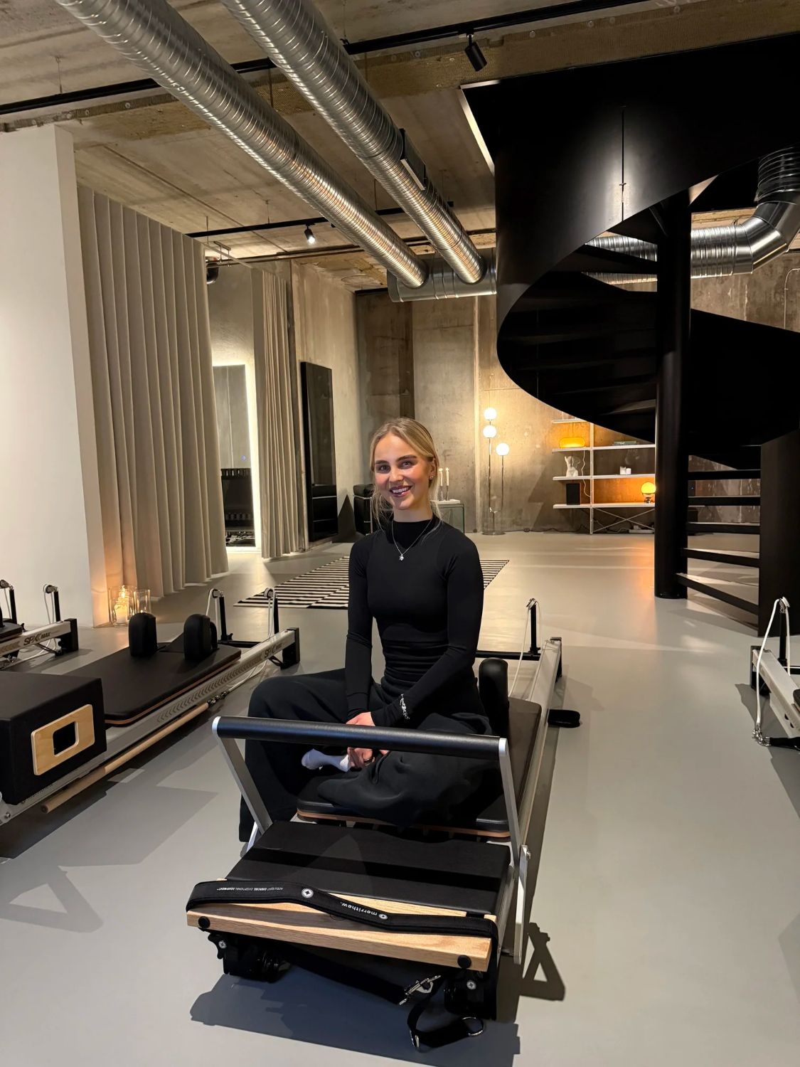 Kamilla, classical Pilates teacher, sitting on a reformer at Sink Reformer, Aarhus