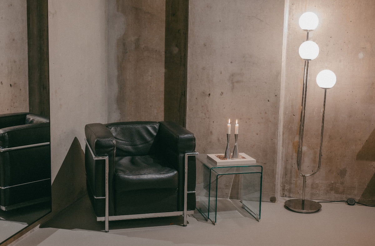 Leather armchair and candles by the concrete wall in the Sink Reformer studio