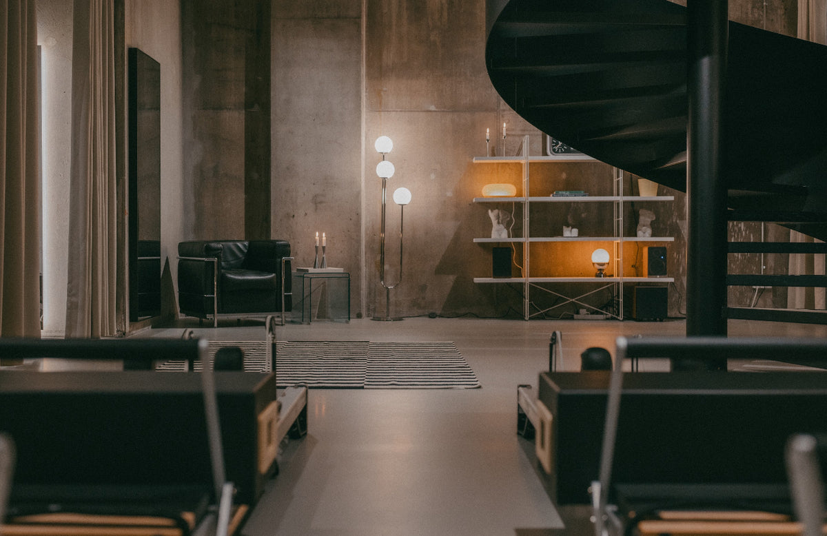 Udsigt over studiet hos Sink Reformer med reformere, et stribet tæppe og varmt lys fra reolen, Aarhus Ø
