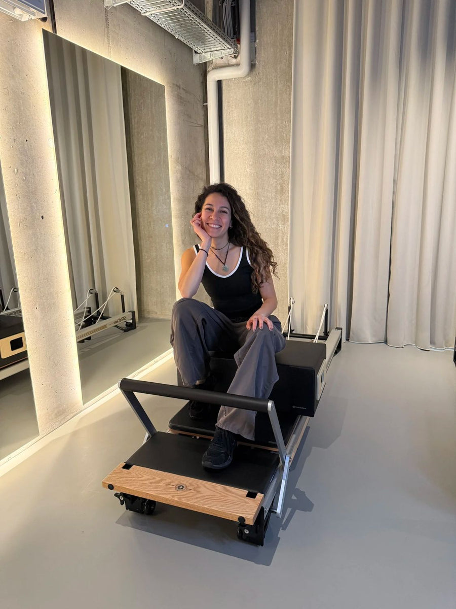 Alejandra, Pilates teacher, sitting on a reformer at Sink Reformer, Aarhus
